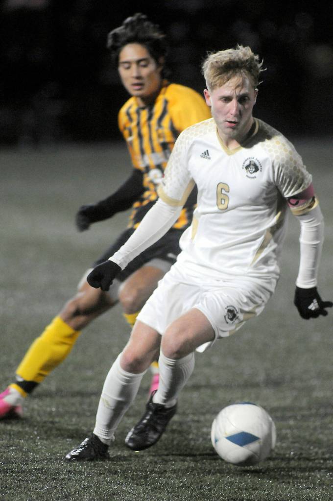 Peninsulas Tim Deser drives across the pitch followed by Walla Wallas Julio Tapia on Saturday evening in Port Angeles. (Keith Thorpe/Peninsula Daily News)