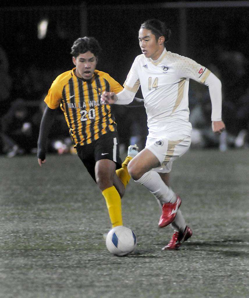 Peninsulas Shu Kato, right, tries to outpace Walla Wallas Nathan Alvarado on Saturday at Wally Sigmar Field. (Keith Thorpe/Peninsula Daily News)