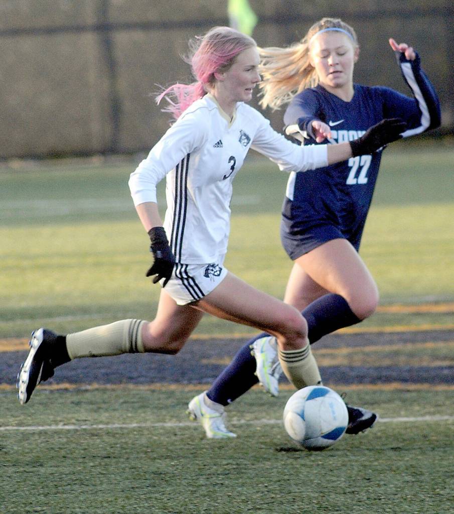 Peninsulas Millie Long, left, races downfield with Spokanes Aubrey Thomas in pursuit during Saturdays NWAC quarterfinal game at Wally Sigmar Field in Port Angeles. (Keith Thorpe/Peninsula Daily News)