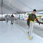 Paul Beck of Port Angeles, right, leads a line of volunteers and others as they carry a chilling element across what will become an ice skating rink on Friday at the Port Angeles Winter Ice Village. (Keith Thorpe/Peninsula Daily News)