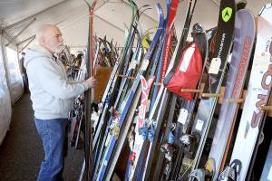 Chris Noble of Port Angeles looks through a selection of used skis during Saturdays annual Hurricane Ridge Ski Club Outdoor Gear Swap at the Coho Ferry parking lot in downtown Port Angeles. Skis, boots, poles, sports clothing and accessories were available through consignment with proceeds benefiting the Hurricane Ridge Ski Team and the Surfrider Foundation. The event preceded this coming Saturdays Winterfest at the Vern Burton Community Center in Port Angeles, which will support capital improvements to the ski area and scholarships to underprivileged children. Tickets can be purchased online at www.hurricaneridge.com. (Keith Thorpe/Peninsula Daily News)