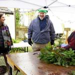 Tuttie Peetz, right, brings her wreath-making equipment and piles of greens, cones and ribbons to the River Center Holiday Nature Mart this weekend. The sale of handcrafted items, holiday wreaths and arrangements, baked goods and candy, is set for Saturday and Sunday to support the Dungeness River Nature Centers education programs. (Submitted photo)