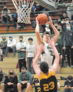 Keith Thorpe/Peninsula Daily News Port Angeles Parker Nickerson, top, take aim at the basket as Bainbridge Islands James Carey defends the lane on Tuesday in Port Angeles.