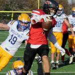 Lonnie Archibald/for Peninsula Daily News
Neah Bay's Jodell Wimberley scores one of his five touchdowns against Wellpinit in the state 1B quarterfinals held in Forks, just getting past Wellpinit's Andrew Moyer (19). Neah Bay won 66-14.