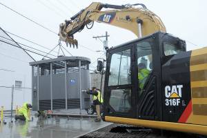 KEITH THORPE/PENINSULA DAILY NEWS
A prefabricated Portland Loo public toilet is lowered into place on a pad at the edge of the Breezeway public parking lot in the 100 block of West Front Street in downtown Port Angeles on Tuesday. The unit, one of two being installed at the location, replaces the original concrete block public restroom that previously occupied the site, with a third slated for The Gateway transit center. The new facilities are ADA-compliant, require no winterization and will be open to the public 24 hours a day, seven days a week.