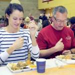 KEITH THORPE/PENINSULA DAILY NEWS
Cecilia Stevenson, of Dallas, left, and her father, Will Stevenson of Port Angeles, say a blessing before enjoying a Thanksgiving meal in the fellowship hall of Queen of Angeles Catholic Church in Port Angeles. The church offered a traditional Thanksgiving dinner for the community, with several hundred diners taking advantage of the in-house meal. Numerous other dinners were sent out for in-home dining.