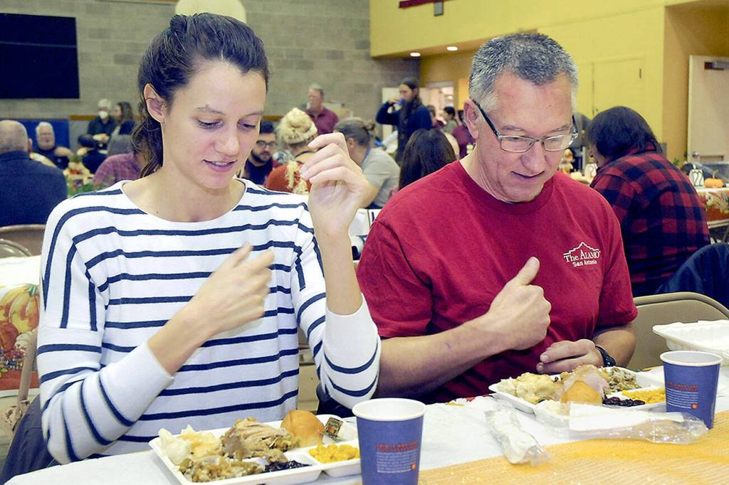 KEITH THORPE/PENINSULA DAILY NEWS
Cecilia Stevenson, of Dallas, left, and her father, Will Stevenson of Port Angeles, say a blessing before enjoying a Thanksgiving meal in the fellowship hall of Queen of Angeles Catholic Church in Port Angeles. The church offered a traditional Thanksgiving dinner for the community, with several hundred diners taking advantage of the in-house meal with numerous other dinners sent out for in-home dining.