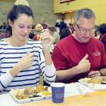 Cecilia Stevenson, of Dallas, left, and her father, Will Stevenson of Port Angeles, say a blessing before enjoying a Thanksgiving meal in the fellowship hall of Queen of Angels Catholic Church in Port Angeles. The church offered a traditional Thanksgiving dinner for the community, with several hundred diners taking advantage of the in-house meal with numerous other dinners sent out for in-home dining. (Keith Thorpe/Peninsula Daily News)