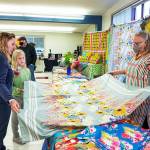 Steve Mullensky/for Peninsula Daily News

Martha Worthley, of Mim and Poppy Design, shows a tablecloth she designed to Alisa Martin and daughter Etta-Pearl, during the Port Townsend Arts Guild Arts and Crafts Fair on Friday at the Port Townsend Community Center in the Uptown neighborhood. The fair continues today from 10 a.m. to 5 p.m.