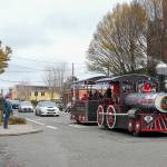 People stop and take pictures of the Port Townsend Kiwanis George Earl Memorial Cho Cho as it clangs along Water Street in downtown Port Townsend on Small Business Saturday. The popular Choo Choo made a circuit from the American Legion to Uptown and back again, delighting passengers and spectators alike. (Steve Mullensky/for Peninsula Daily News)