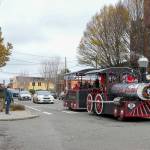 People stop and take pictures of the Port Townsend Kiwanis George Earl Memorial Cho Cho as it clangs along Water Street in downtown Port Townsend on Small Business Saturday. The popular Choo Choo made a circuit from the American Legion to Uptown and back again, delighting passengers and spectators alike. (Steve Mullensky/for Peninsula Daily News)