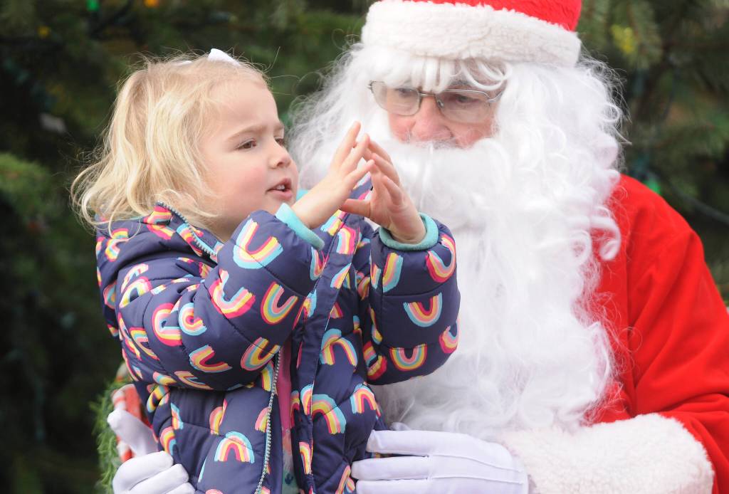 Michael Dashiell / Olympic Peninsula News Group
Finley Loveless, 3, of Sequim spends some quality time with Santa Claus (Stephen Rosales) at the Hometown Holidays event Saturday afternoon in downtown Sequim. Along with photos with Santa and the royalty, other festivities included live music, a tree-lighting ceremony, Sequim Museum & Arts Tractor Parade and more.
