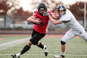 Maria Dorsten/for Peninsula Daily News
Neah Bay quarterback Julian Carrick is facemasked by a Liberty Christian defender on one of his big runs Saturday in the state 1B semifinals held at Mount Tahoma High School in Tacoma. Carrick scored six touchdowns as Neah Bay won 82-24. The Red Devils will face Liberty Bell next week in the championship game.