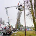 Joe Suter and Dave Smith, employees of Palouse Power, which contracts for additional services to Jefferson County Public Utility District, have snow flurries fall on them as they work to lift a communications cable, owned by Lumen, that was torn down Sunday morning by a boat on a trailer that snagged the cable at the entrance as it entered the boat yard, workers said. The PUD secured the cable as a public service so the entrance could be opened for business on Monday. (Steve Mullensky/for Peninsula Daily News)