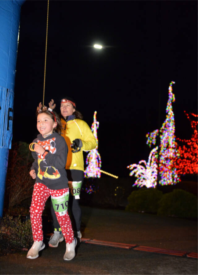 Elena Guillen-Kushner, 7, of Bainbridge Island crosses the finish line at the Jamestown SKlallam Run just in front of Siri Kushner, also of Bainbridge. (Courtesy of Run The Peninsula)
