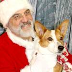 Santa, Christopher Thomsen, holds Lizzie on Sunday at Airport Garden and Nursery in Port Angeles as part of a fundraiser for the Peninsula Friends of Animals. More than a dozen dogs, some more wiggly than others, sat in Santas lap for a photo. (Dave Logan/for Peninsula Daily News)