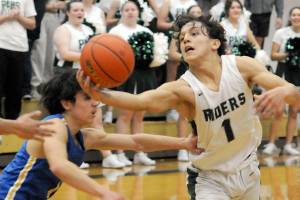 KEITH THORPE/PENINSULA DAILY NEWS
Port Angeles' Kason Albaugh pulls down a loose ball as Bremerton's David Klega, left, tries to push him away during Tuesday's matchup at Port Angeles High School.
