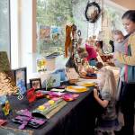 KEITH THORPE/PENINSULA DAILY NEWS
Molly Brown of Port Angeles, and her children, Lucy Brown, 3, and Oliver Brown, 5 months, examine a display of loally-produced art items for sale as gifts on Thursday during the holiday Makers Market at the Port Angeles Fine Arts Center. The market, open Thursday through Sunday from 11 a.m. to 5 p.m. and from 5 p.m. to 8 p.m. today and Dec. 16,  will observe extended. hours of 11 a.m. to 8 p.m. during the Wintertide Festival of Lights on Saturday..