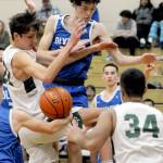 Port Angeles Tyler Hunter, left, and Olympics Stephen Iugler, center, tangle in the lane as Port Angeles Parab Seera looks on at right during Tuesday nights matchup at Port Angeles High School. (Keith Thorpe/Peninsula Daily News)
