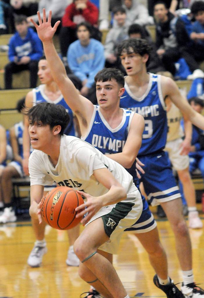 KEITH THORPE/PENINSULA DAILY NEWS
Port Angeles' Nathaneal Surina, left, looks for his teammates as Olympic's Keithen Whitener, center, and Stephen Kugler, rear, defend the lane on Tuesday night in Port Angeles.