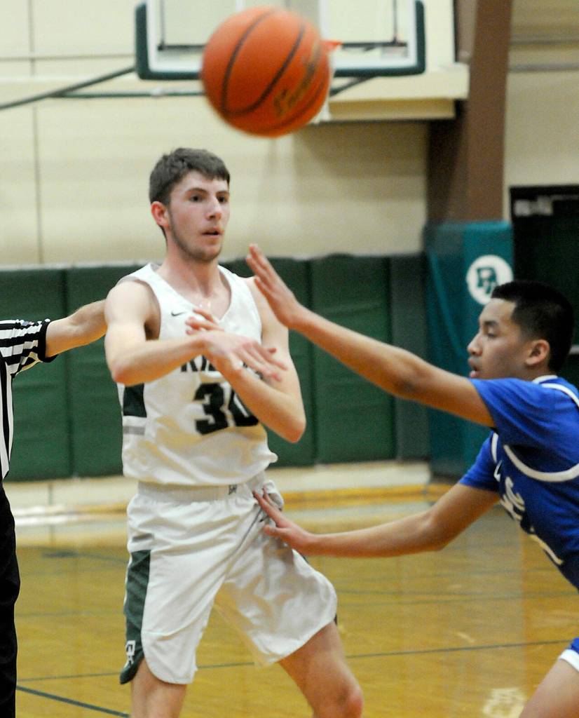 KEITH THORPE/PENINSULA DAILY NEWS
Port Angeles' Bryant Hoch, left, passes around Olympic's Sean Clegg on Tuesday in Port Angeles.