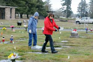 Jan Urfer, left, and Anita Reynolds scout out headstones on Thursday that will receive a wreath for Saturdays Wreaths Across America ceremony at Mount Angeles Memorial Park in Port Angeles. The women, members of the Michael Trebert Chapter of the Daughters of the American Revolution, were helping prepare for the event, which honors veterans for their service. Around 2,700 sponsored wreaths are planned for placement at Blue Mountain, Dungeness, Gardiner, Sequim View, Mount Angeles and Forks cemeteries, with a formal service planned for 11 a.m. Saturday at Mount Angeles. (Keith Thorpe/Peninsula Daily News)