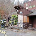 Port Angeles firefighters stage for entry into the former Bushwhacker restaurant during a fire training session on Friday. The exercise included filling the building with smoke to simulate the experience of a real fire and the use of a mannequin for rescue drills. Fire department Capt. Kelly Ziegler said the building would not be intentionally burned, but indicated that it was slated for eventual demolition. (KEITH THORPE/PENINSULA DAILY NEWS)