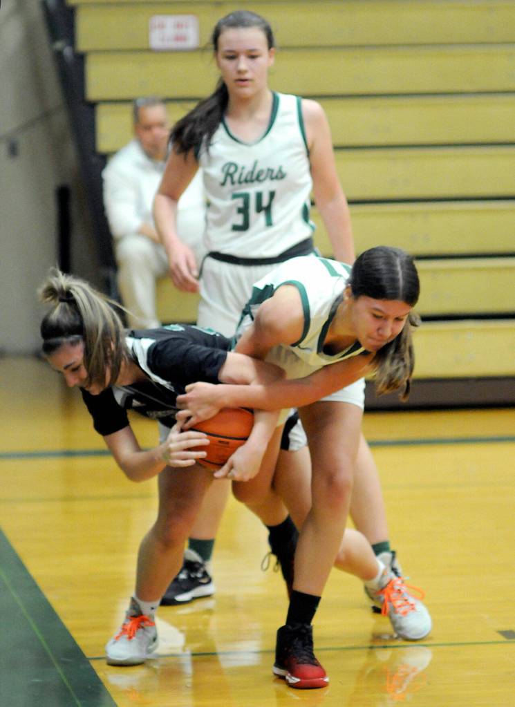 Port Angeles Lindsay Smith, right, fights for the ball with Peninsulas Brooke Zimmermann as Smiths teammate, Lexie Smith, looks on during Saturdays match-up at Port Angeles High School. (Keith Thorpe/Peninsula Daily News)