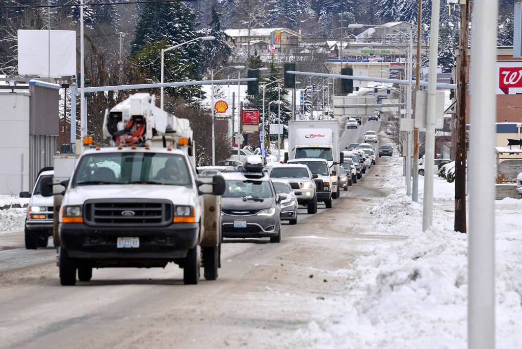 Roads conditions are expected to remain hazardous through Friday evening as several days of snow turns to rain on the Olympic Peninsula. Major roads like Highway 101 through Port Angeles were mostly plowed Thursday, though many secondary roads and neighborhood streets remained covered in packed ice. (Peter Segall/Peninsula Daily News)