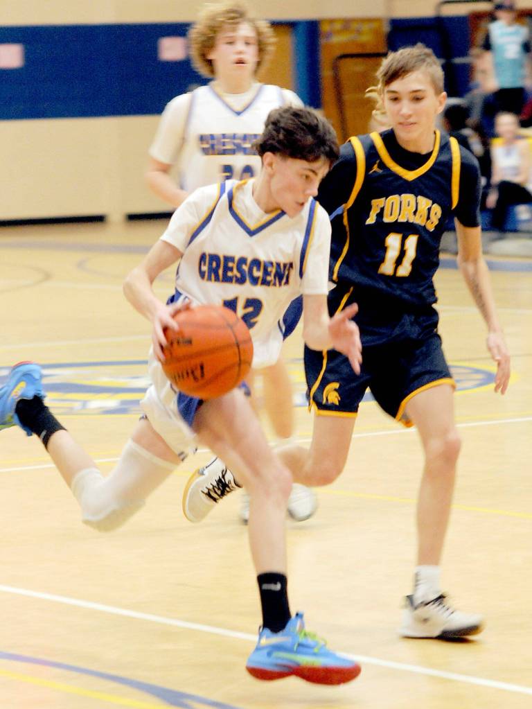 Crescents Conner Bauers, front, drives downcourt pursued by Forks Kyle Lohrengel, right, as teammate Henry Bourm follows behind on Wednesday afternoon at Crescent High School in Joyce. (Keith Thorpe/Peninsula Daily News)