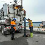 Steve Mullensky/for Peninsula Daily News

Rafe Thornton, left, and Lane Dotson, both with the City of Port Townsend Street, Sewer and Storm department vacuum sewage out of the manhole and into the truck, on Thursday, in order to facilitate repairs to the broken sewer line at Gaines and Water Streets in Port Townsend, on a newly installed sewer line damaged by recent storm and tidal activity.