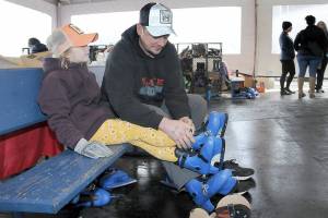 KEITH THORPE/PENINSULA DAILY NEWS
Steve Evans of Port Angeles assists his daughter, Ruby Evans, 7, with her skates prior to a session on the ice on Friday at the Port Angeles Winter Ice Village.