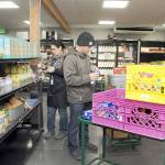 KEITH THORPE/PENINSULA DAILY NEWS
Analise Graziani, manager of The Market at the Port Angeles Food Bank, left, and Adam Frandsen, a food bank staff member with Americorps, stock shelves at The Market before opening to the public on Thursday.