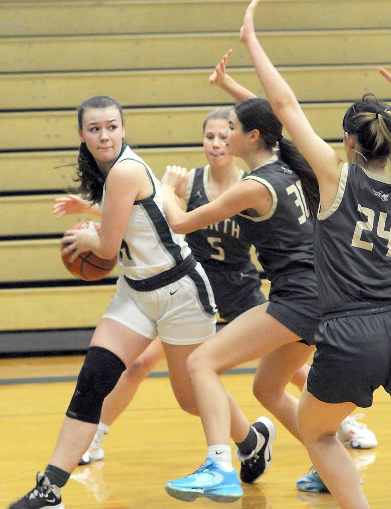 Port Angeles Lexie Smith, left, looks for a chance to pass around North Kitsap defenders, from left, Evelyn Beers, Megan Komar and Jade Sunnenberg on Tuesday night in Port Angeles. (Keith Thorpe/Peninsula Daily News)