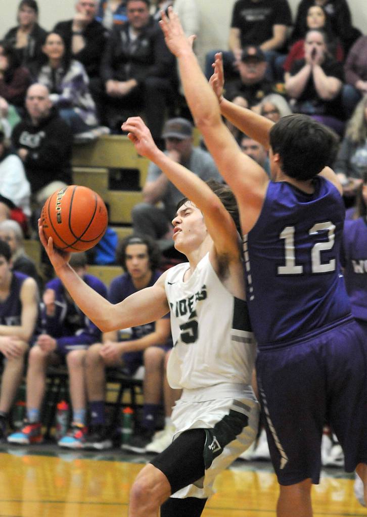 KEITH THORPE/PENINSULA DAILY NEWS
Port Angeles' Parker Nickerson, left, sets up for a hook shot over Sequim's Espn Judd on Tuesday at Port Angeles High School.