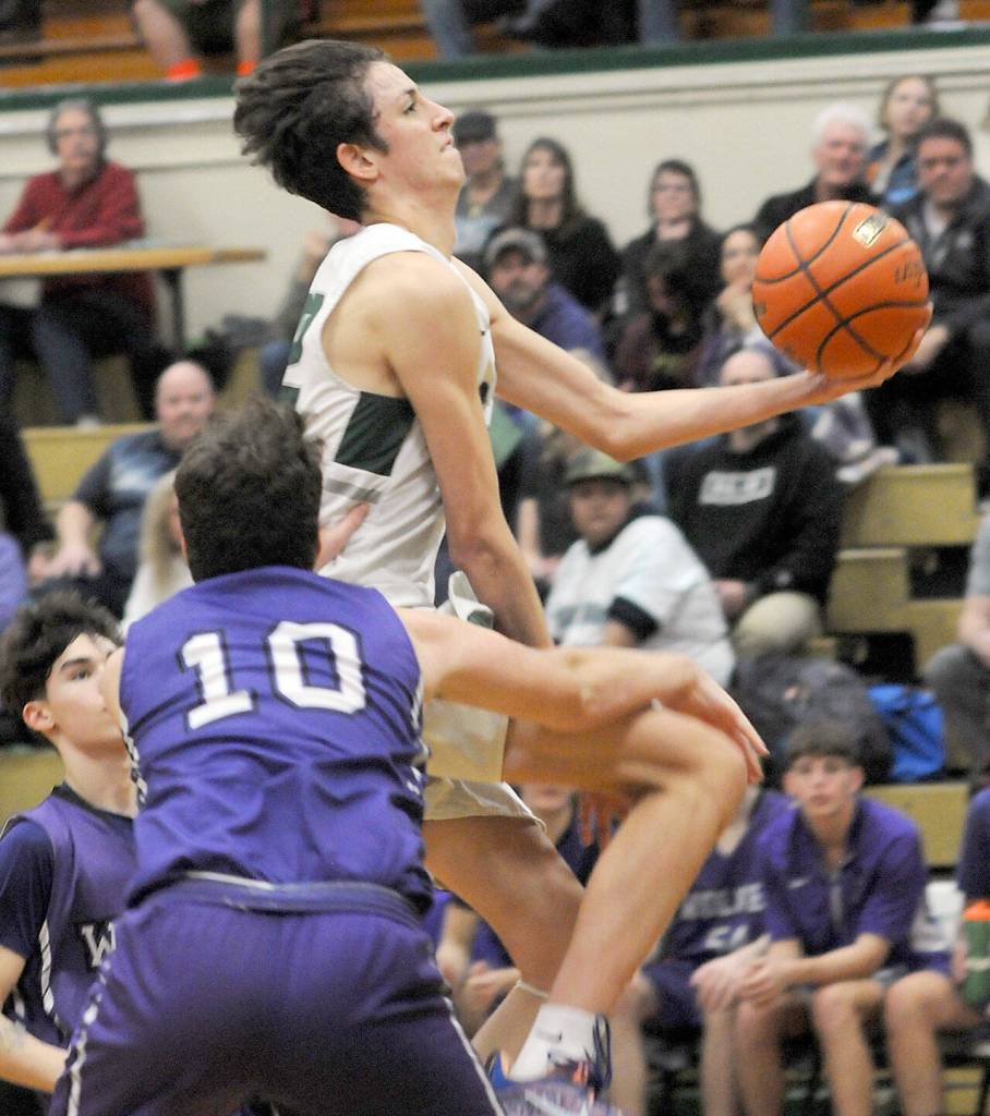 KEITH THORPE/PENINSULA DAILY NEWS
Port Angeles' Tyler Hunter looks for the layup as Sequim's Keenan Green tries to block his progress on Tuesday night at Port Angeles High School.