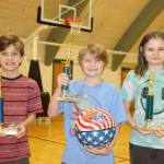 The first-place Elks Hoop Shoot Winners from the city championships held this weekend at the Vern Burton Gym receive tehir trophies. From left, they are Levi Simoneau, 11, from Franklin Elementary School, who shot 18 out of 25 to win the boys 10-11 age group; Logan Wasnock, 8, from Jefferson Elementary, who shot 13 out of 25 to win the boys 8-9 age group; and Lillian Wasnock, 11, from Jefferson Elementary, who shot 10 out of 25 to win the girls 10-11 age group. Second-place winners were James Boyd, 13 out of 25 in the 8-9 age group and Ernest Grimes Jr., 14 out of 25 in the 10-11 age group. The first-place winners will compete in the district championship this Saturday at Vern Burton Gym. (Dave Logan/for Peninsula Daily News)
