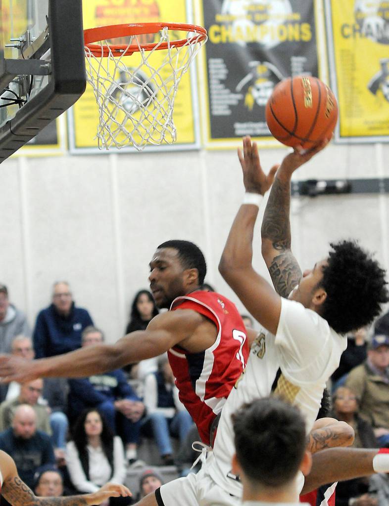 KEITH THORPE/PENINSULA DAILY NEWS
Peninsula's Javon Ervin, right, fades back for the shot past Skagit Valley's Omari Maulana on Wednesday night in Port Angeles.