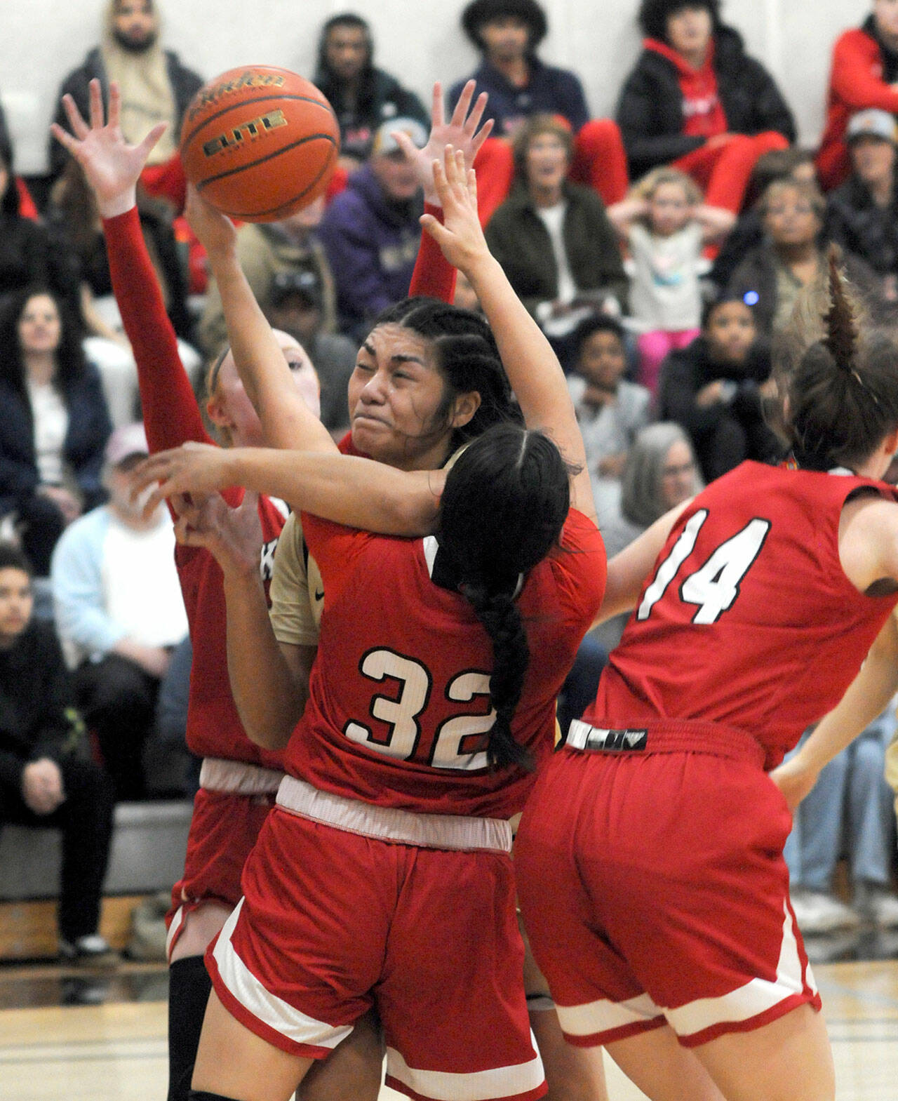 Peninsulas Ituau Tuisaula, center, bulls her way through the Skagit Valley defenders, from left, Kailyn Allison, Sarah Cook and Janae Rhoads on Wednesday night in Port Angeles. (Keith Thorpe/Peninsula Daily News)