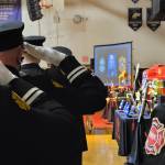 Firefighters pay tribute to Capt. Charles Chad Cate at a memorial service at Sequim High School on Saturday. (Michael Dashiell/Olympic Peninsula News Group)