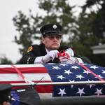 Scott Dickson, longtime firefighting partner of Capt. Charles Chad Cate, removes straps securing Cates casket at a memorial Saturday afternoon for the firefighter who was found deceased while on shift on Jan. 12. (Olympic Peninsula News Group)