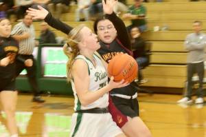 Port Angeles' Anna Petty goes around a Kingston defender in the Roughriders' 55-25 win at home Tuesday night. Petty scored 17 points to lead the Riders. (Dave Logan/for Peninsula Daily News)