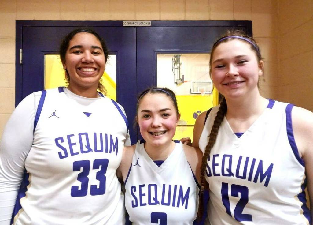 Sequim seniors Jelissa Julmist, Hannah Bates and Sammie Bacon celebrate their teams Olympic League championship Thursday night. (Pierre LaBossiere/Peninsula Daily News)