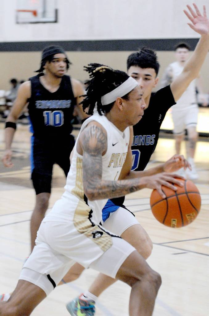 Peninsulas Mikey Medlock Jr., front, heads for the lane against Everetts Leon Sayers on Jan. 28 in Port Angeles. (Keith Thorpe/Peninsula Daily News)
