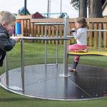 Braxton Stewart, 3, of Mill Creek pushes a merry-go-round as Kiara Ann, 4 of Sequim gets a free ride on Wednesday at the Dream Playground at Erickson Playfield in Port Angeles. The pair were enjoying a cool but clear late-winter day on the North Olympic Peninsula. (Keith Thorpe/Peninsula Daily News)