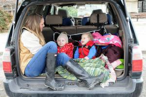 Katie Roszatycki of Port Angeles and her children, June Roszatycki, 2, and Asher Roszatycki, 3, sit in the back of their car waiting for the delivery of dry shoes and socks from another family member after an outing to Hollywood Beach on Thursday. The family was keeping themselves entertained in the parking lot at Port Angeles City Pier. (Keith Thorpe/Peninsula Daily News)