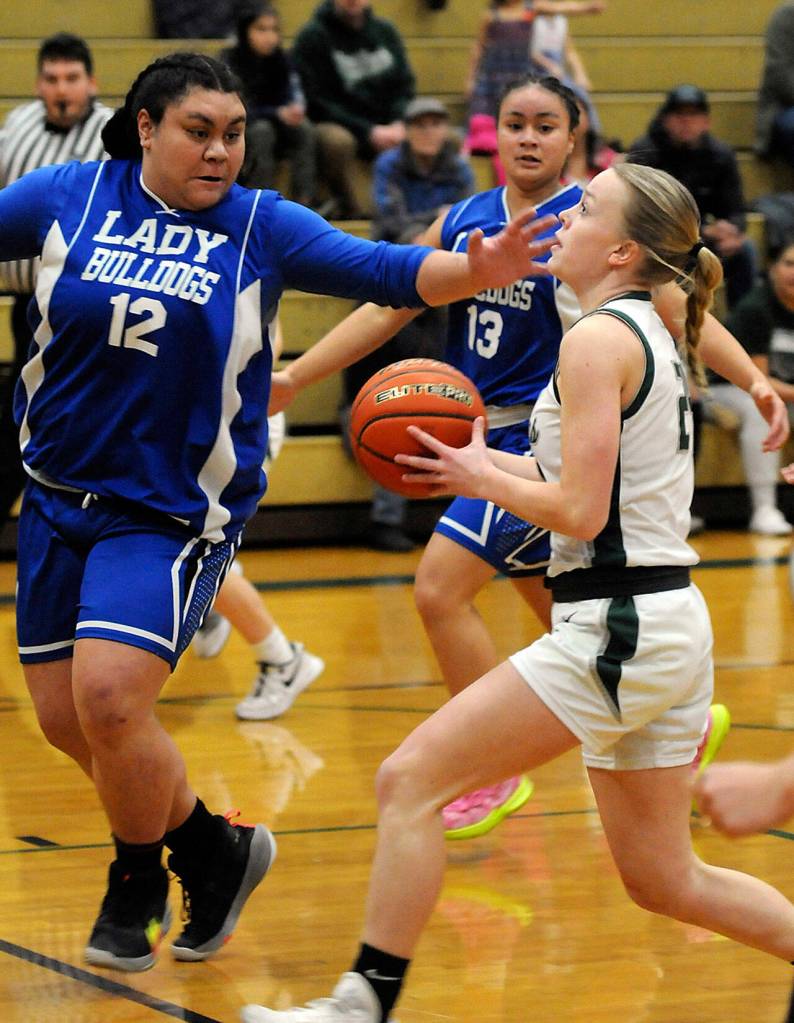 Keith Thorpe/Peninsula Daily News Port Angeles Anna Petty heads for the paint as North Masons Tanza Tupolo, left, and Adrianna Tupolo put up their defense on Thursday in Port Angeles.