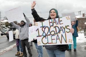 KEITH THORPE/PENINSULA DAILY NEWS
Jenni Tiderman of Port Angeles, front, holds a sign celebrating her five years of addiction recovery during "birthday bash" and resource fair hosted by Reflections Counseling Services Group on Thiursday at Veterans Park in Port Angeles. The event featured representatives from numerous drug and alcohol addiction and homelessness support agencies, as well as free meals and clothing for those in need.
