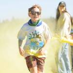 Owen DeAngelo grins as he gets a touch of yellow at the last color station at the Sun Fun Color Run 5K in 2022 at the Albert Haller Playfields just north of Carrie Blake Community Park. Entries remain open for the 1K and 5K run/walk races on Saturday. (Michael Dashiell/Olympic Peninsula News Group)