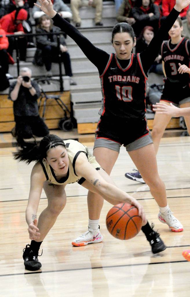 Peninsulas Adam Kaganak reaches low in the lane as Everetts Jayda Pittman tries to defend on Wednesday night in Port Angeles. (Keith Thorpe/Peninsula Daily News)